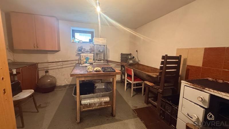 Eine Küche in einem Einfamilienhaus mit einfacher Möblierung und Geräten zur Lebensmittelverarbeitung.