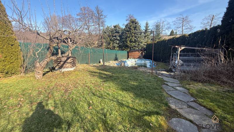 Der Garten des Einfamilienhauses in Lutila mit Bäumen und einem Gehweg in sonniger Umgebung.