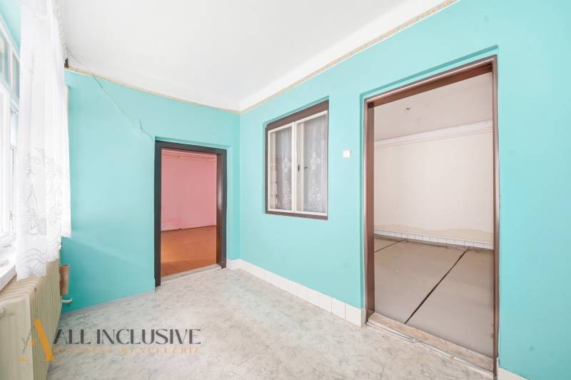 Ein Zimmer in einem Einfamilienhaus mit bunten Wänden, Laminatboden und einem großen Fenster.