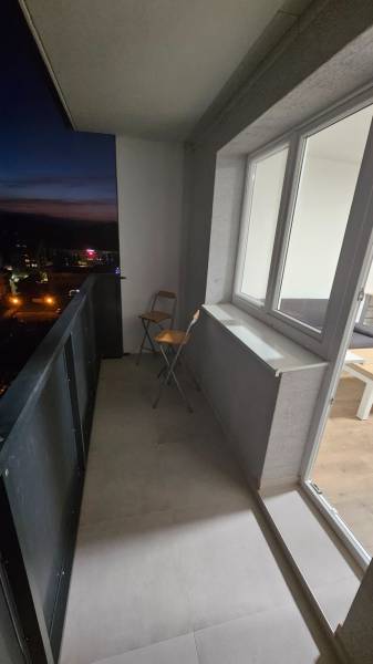 Balkon eines Einzimmerapartments in Pod Hájom, Dubnica nad Váhom, mit Klappstuhl und Fliesenboden.