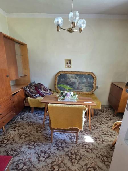 Das Einfamilienhaus enthält ein Esszimmer mit Teppichboden, Möbeln und einem hängenden Kronleuchter.