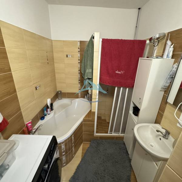 Badezimmer in einer 3-Zimmer-Wohnung mit Badewanne, Waschbecken und Waschmaschine; Stauraum.