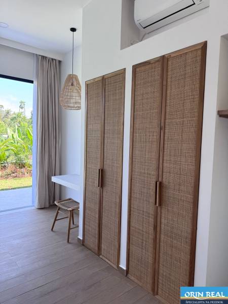 Innenraum eines Einfamilienhauses mit Holzboden und Rattan-Elementen.