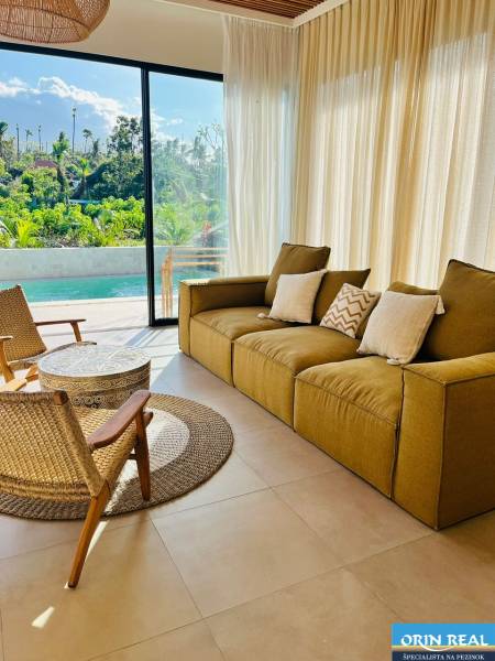 Wohnzimmer eines Einfamilienhauses mit großem Fenster, Blick auf den Garten und Pool.