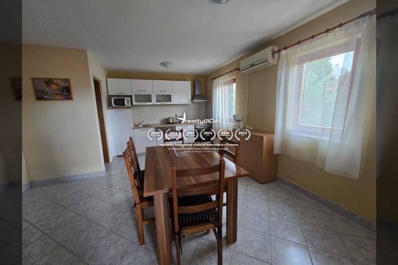 Esszimmer mit Tisch, Stühlen und Küchenzeile in besonderen Immobilien.