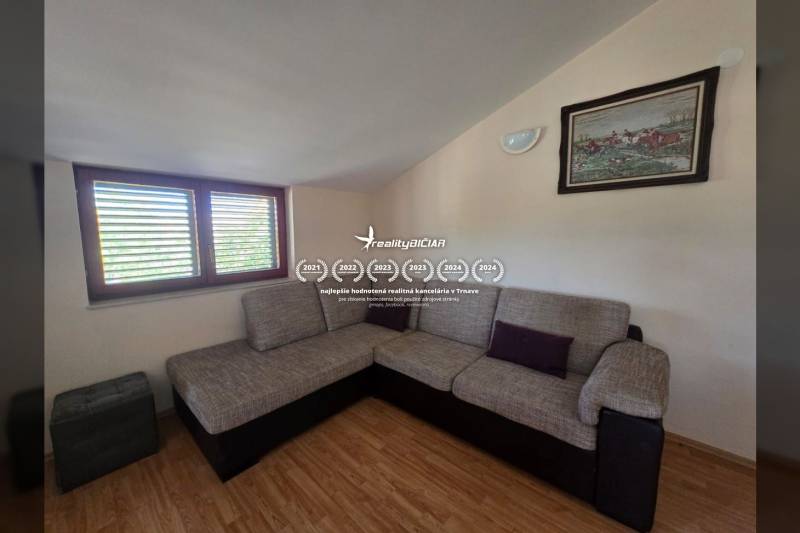 Ein Sofa in der Ecke des Zimmers mit einer Sitzgarnitur, Holzboden, Wandbild.