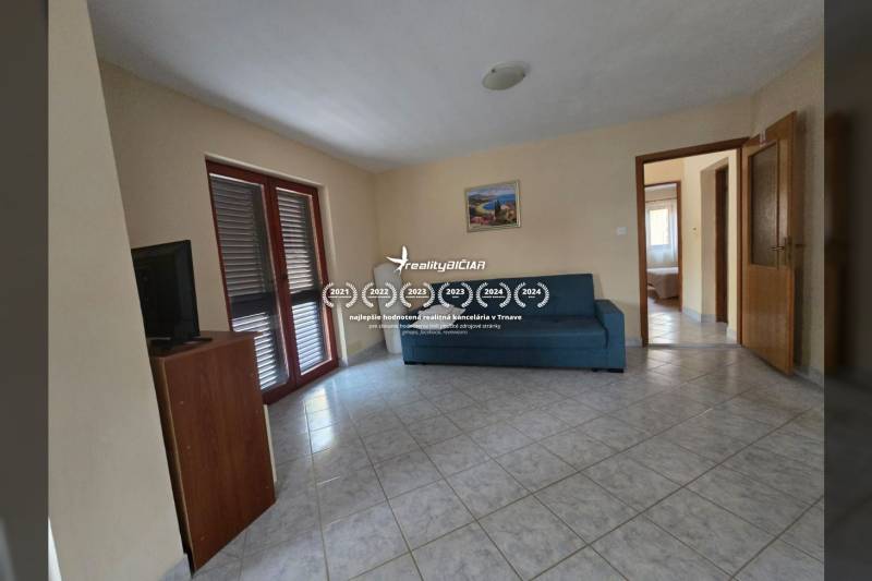 Ein Interieur mit einem Sofa, einem Fernseher und einem gefliesten Boden in besonderen Immobilien.