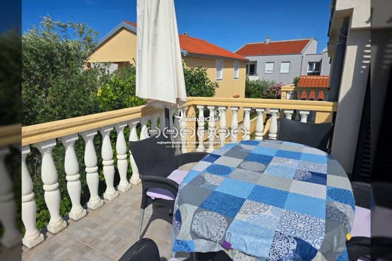 Ein Balkon mit Sitzgelegenheiten auf einer Immobilie in Vrsi in der Straße Mulo, der ideale Ort zum Entspannen.