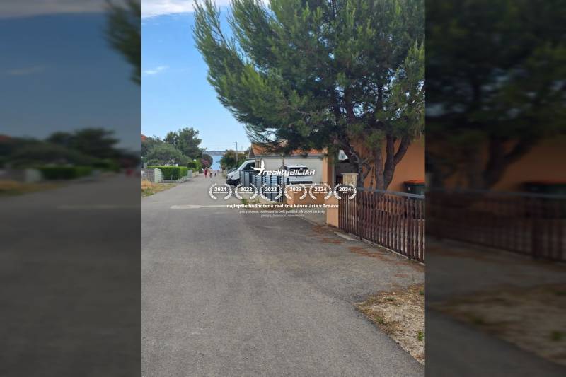 Mulo-Straße in Vrsi mit Bäumen und geparkten Autos, besondere Immobilien.