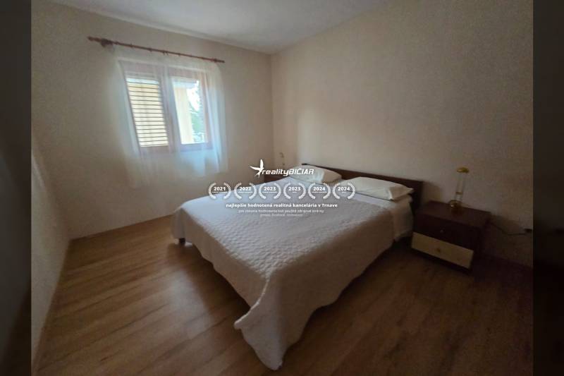 Schlafzimmer mit heller Wand, Bett und Boden mit Holzdekor in besonderen Immobilien.