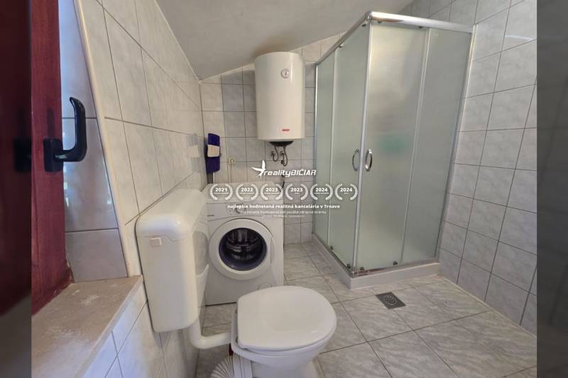 Ein Badezimmer ausgestattet mit einer Waschmaschine, einer Duschkabine und einem Boiler in Besonderen Immobilien.