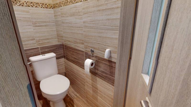 Badezimmer mit Wänden in Holzdekor in einer 2-Zimmer-Wohnung.