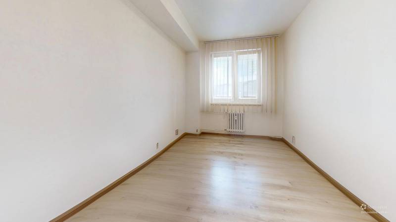 Helles Zimmer mit Fenster und Holzboden in einer 2-Zimmer-Wohnung.