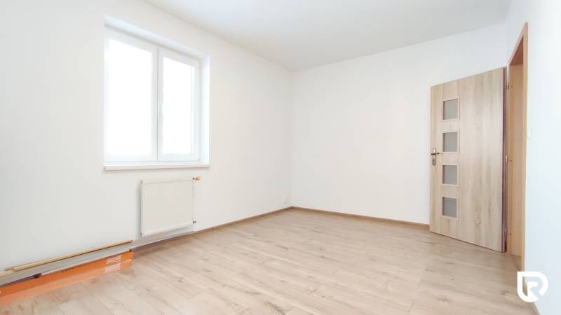 Ein heller Raum mit Holzdekorboden in einer Zweizimmerwohnung.