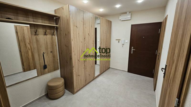 Der Flur in der 2-Zimmer-Wohnung mit Möbeln in Holzoptik und einem eingebauten Spiegel.