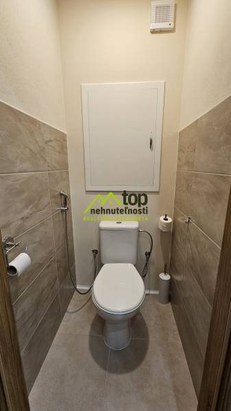 Toilette mit Fliesen und Keramiktoilette in einer 2-Zimmer-Wohnung.