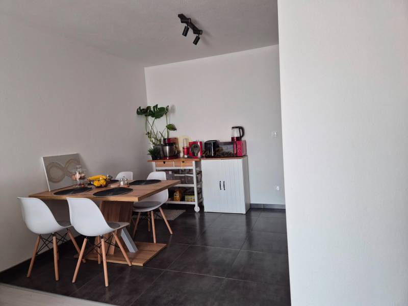 Essbereich mit Holztisch, vier Stühlen und einer Pflanze in einer 3-Zimmer-Wohnung.