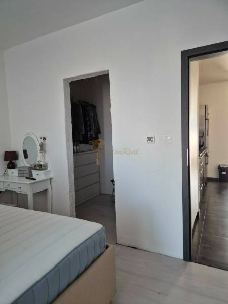 Schlafzimmer mit Spiegel, Zugang zum Kleiderschrank und Flur in einer 3-Zimmer-Wohnung.