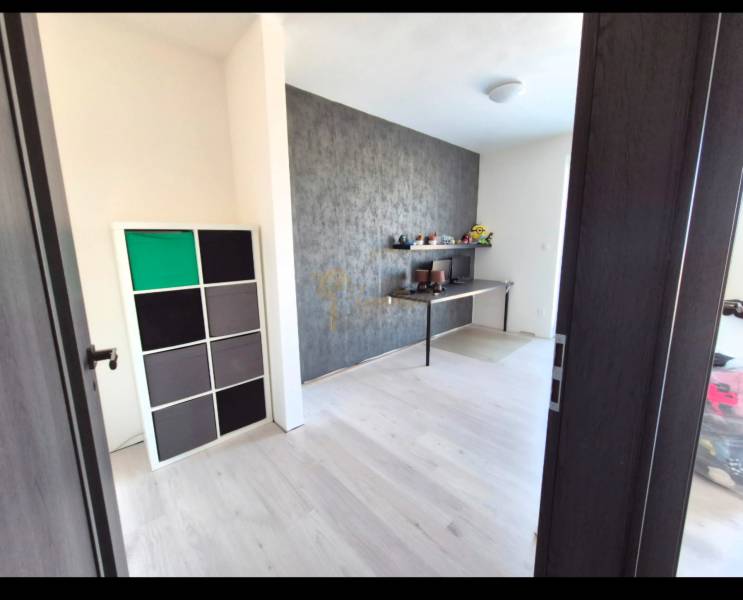 Ein Zimmer in einer 3-Zimmer-Wohnung mit einem Boden in Holzoptik und einer dekorativen Wand.