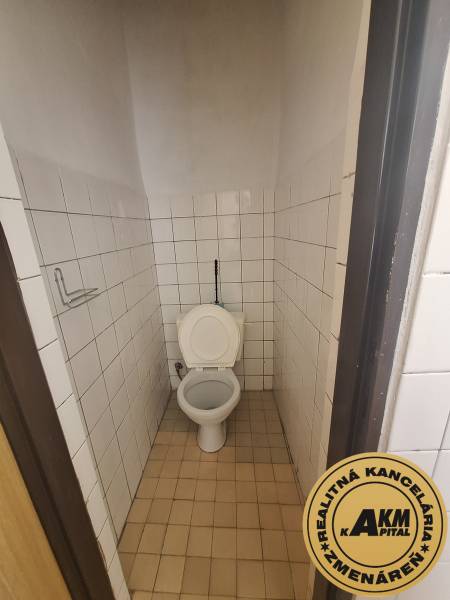 Toilette mit Fliesen im Büro, Boden mit Keramikdekor.