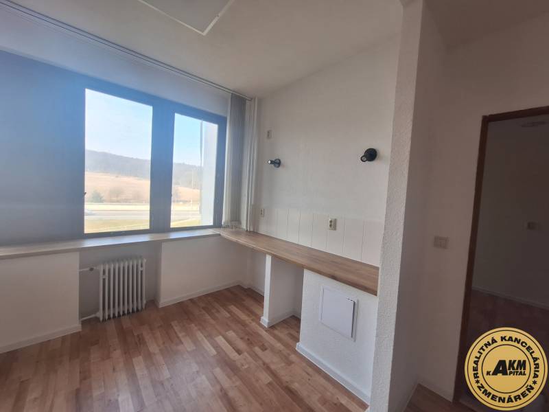 Gewerbeflächen mit Holzbodenoptik und großem Fenster.