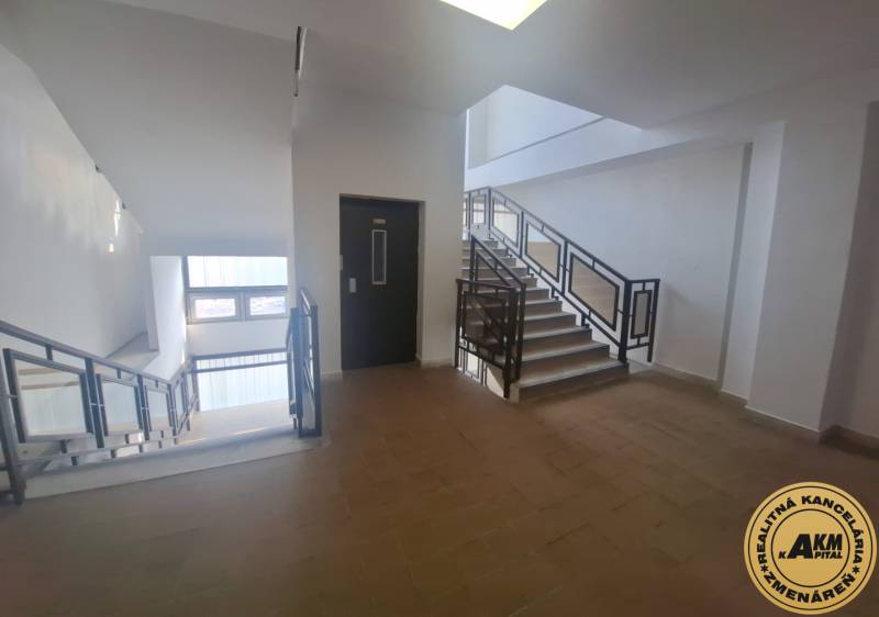 Eine Treppe in Geschäftsräumen mit Fenstern und einem Boden in Holzoptik.