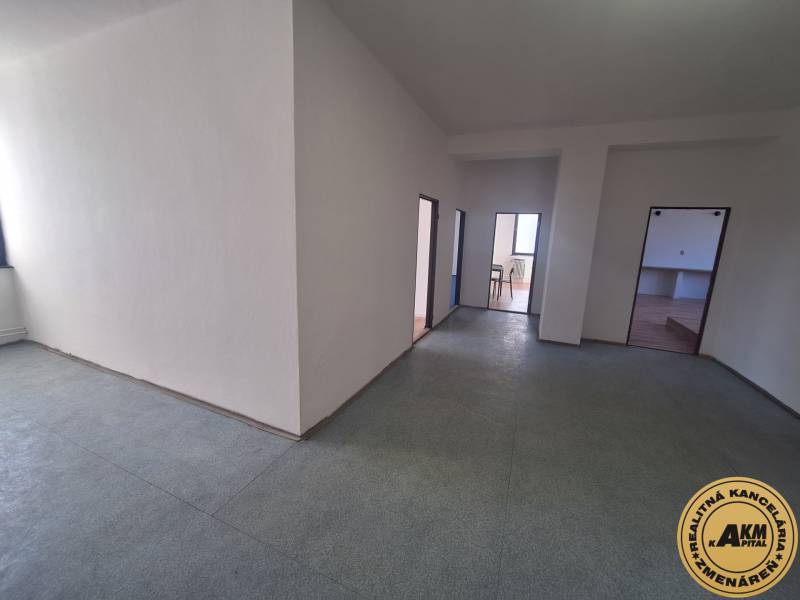 Innenfotografie eines Raumes mit hellen Wänden und drei Türen, Boden mit Holzdekor.