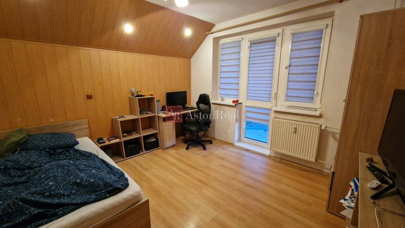 Schlafzimmer in einer 3-Zimmer-Wohnung mit Holzboden, Schreibtisch und Bett.