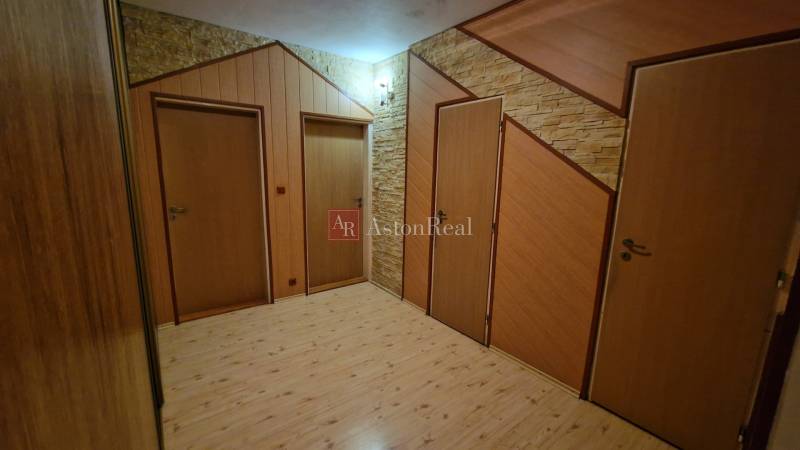 Ein Flur mit drei Türen und einem Boden in Holzoptik in einer 3-Zimmer-Wohnung.