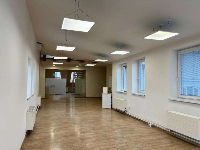 Büros mit Holzboden, Pendelleuchten und Glastüren.