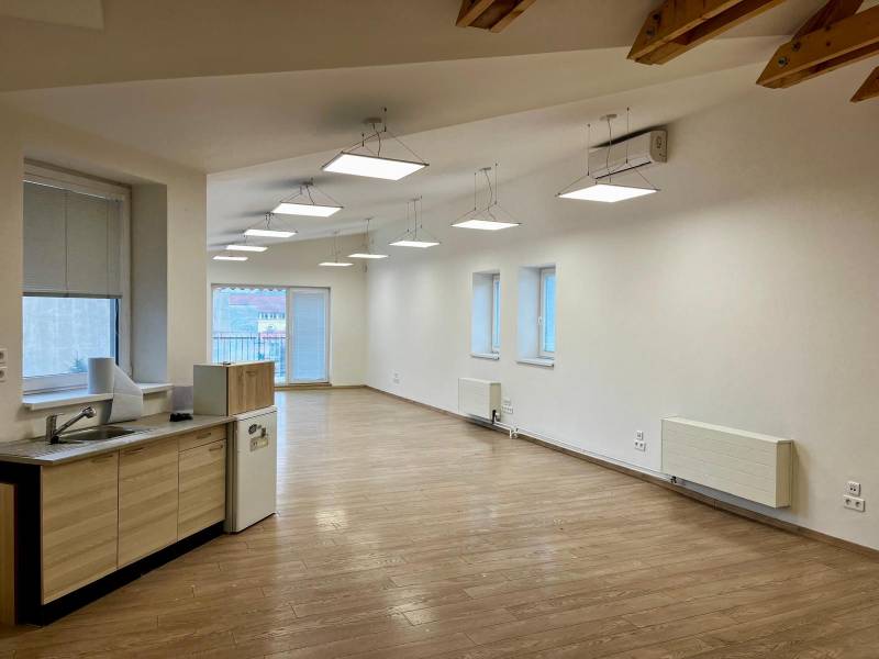 Büros mit Holzboden und Küchenzeile, Deckenbeleuchtung.