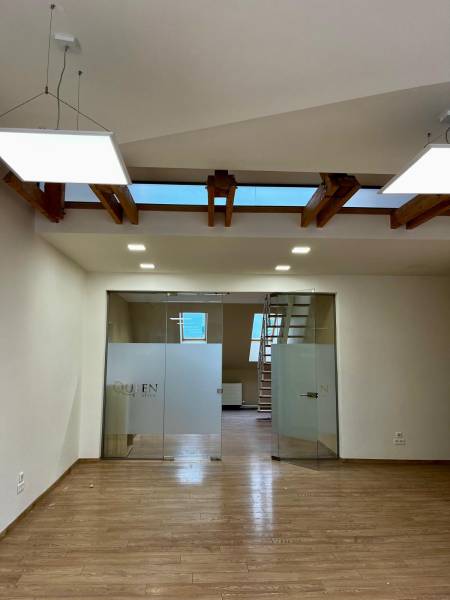 Innenraum eines Büros mit Holzboden und Glastüren.