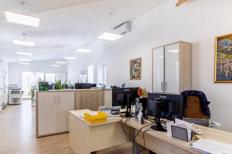 Büros mit Holzboden, Schreibtischen und Lagerschränken.