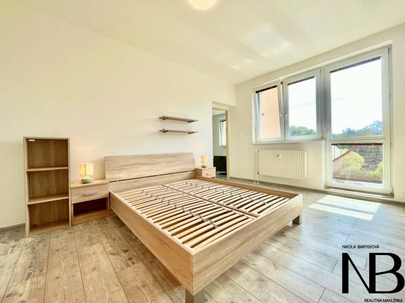 Helles Zimmer mit Holzboden, Bett und Möbeln, 2-Zimmer-Wohnung in der Východná-Straße.
