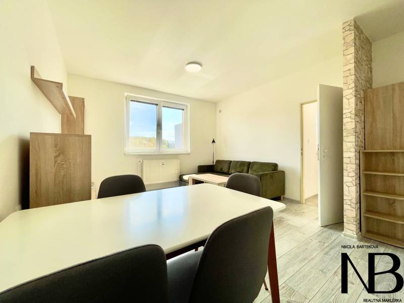 Wohnzimmer in einer 2-Zimmer-Wohnung mit Holzboden, Sofa und Esstisch.