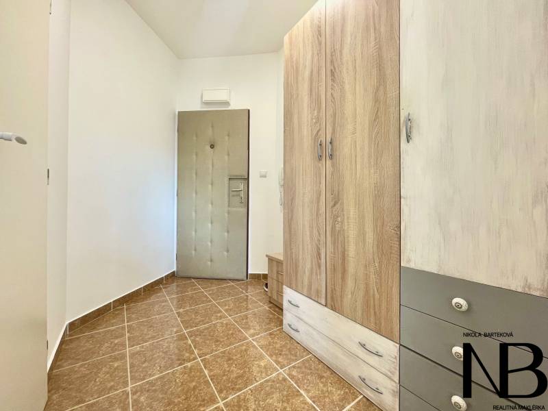 Eingangsflur mit Fliesen, großem Schrank und Sicherheitstür in einer 2-Zimmer-Wohnung in der Východná-Straße.