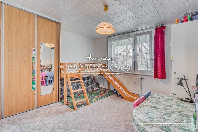 Kinderzimmer mit Etagenbett, Schränken und bunten Stühlen in einer Vierzimmerwohnung.