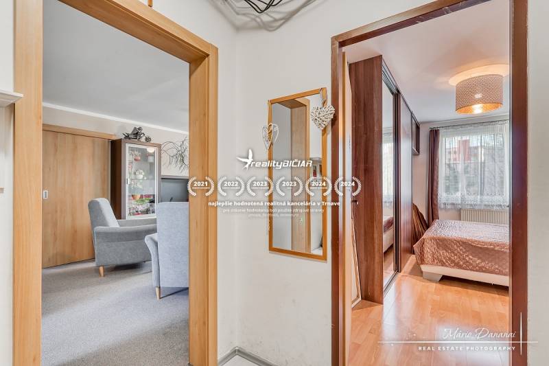 Innenraum einer 4-Zimmer-Wohnung mit Holzboden, Möbeln und Spiegel.