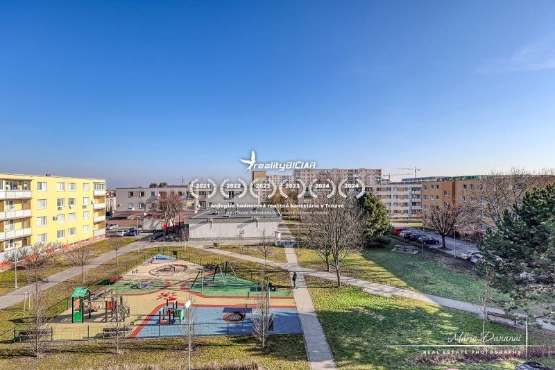 Der Kinderspielplatz, umgeben von Wohnhäusern in der Veterná-Straße in Trnava, bietet einen Blick auf eine 4-Zimmer-Wohnung.