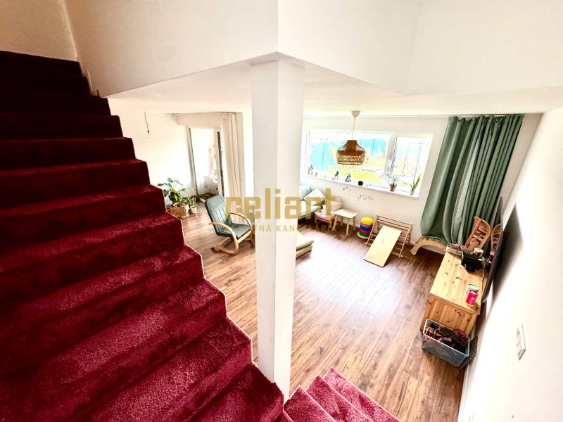 Innenraum eines Einfamilienhauses mit Treppe und Wohnzimmer mit Holzboden.