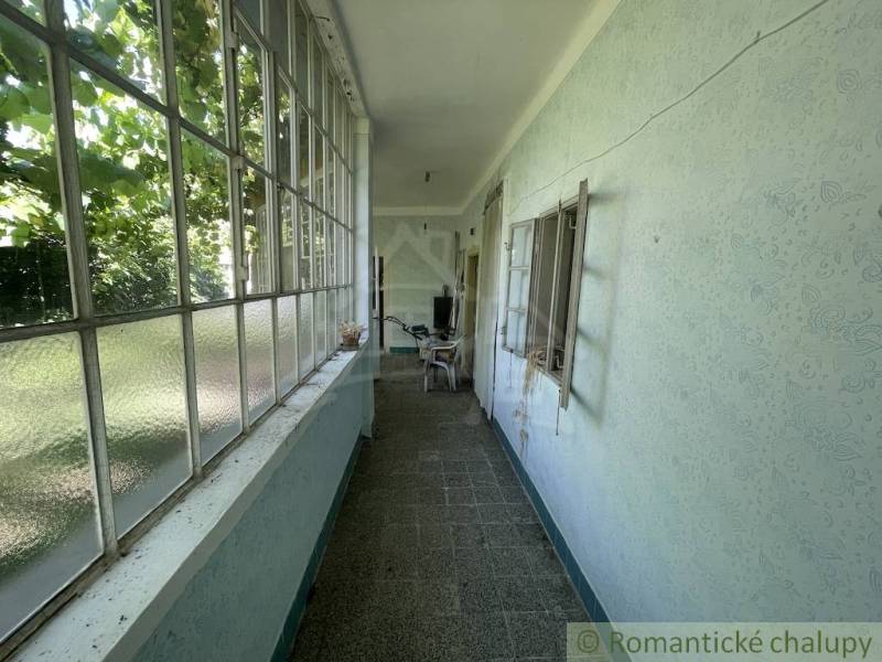 Ein schmaler verglaster Raum in einem Einfamilienhaus mit Blick auf den Garten.