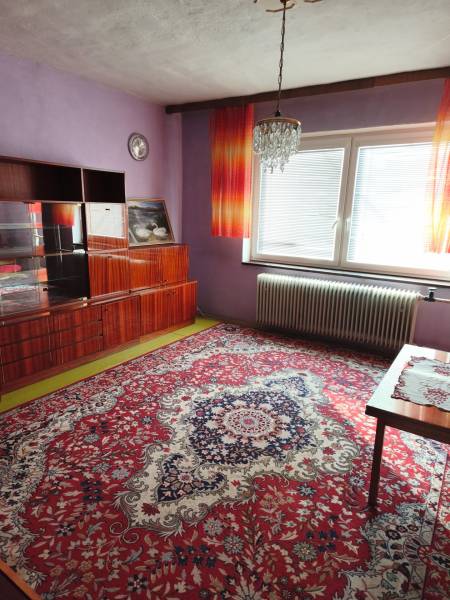 Lila Wände und ein luxuriöser Kronleuchter schmücken den Raum in einem Einfamilienhaus mit einem auffälligen Teppich.