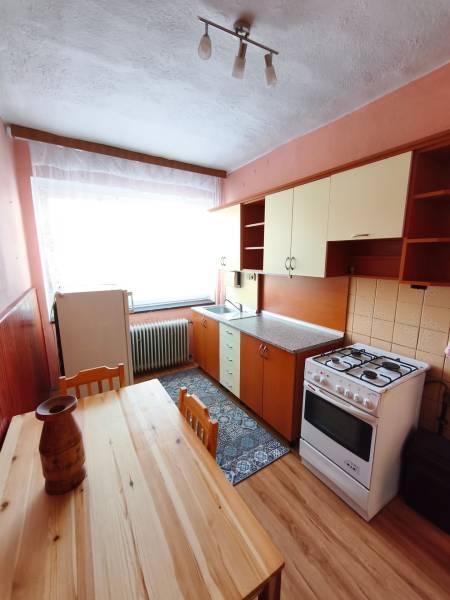 Küche in einem Einfamilienhaus mit Holzboden, Gasherd, Esstisch.