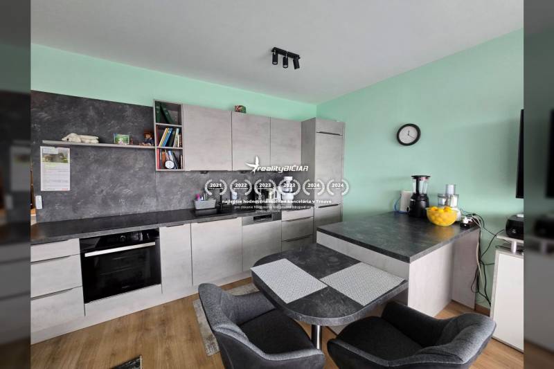 Küche mit Esstisch und Boden in Holzoptik im Ferienapartment.