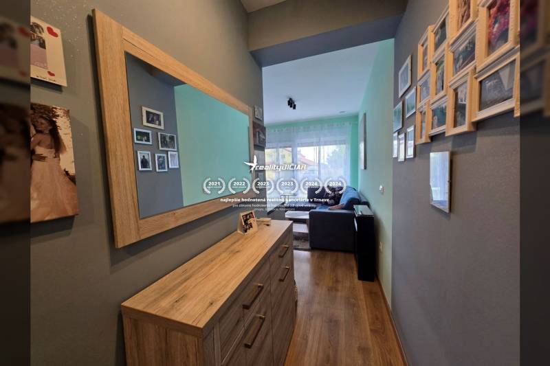 Eine Halle in einem Ferienapartment mit einem Holzboden und einem Spiegel an der Wand.