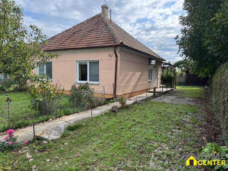 Ein Einfamilienhaus in Komárno mit einem Rasen im Garten und Bäumen auf einem gepflegten Grundstück.