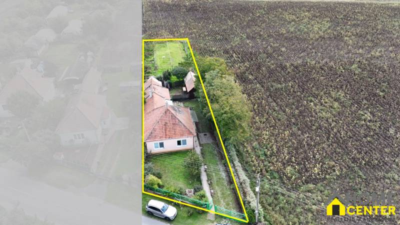Ein Einfamilienhaus in Komárno mit einem großen Grundstück neben einem Feld.