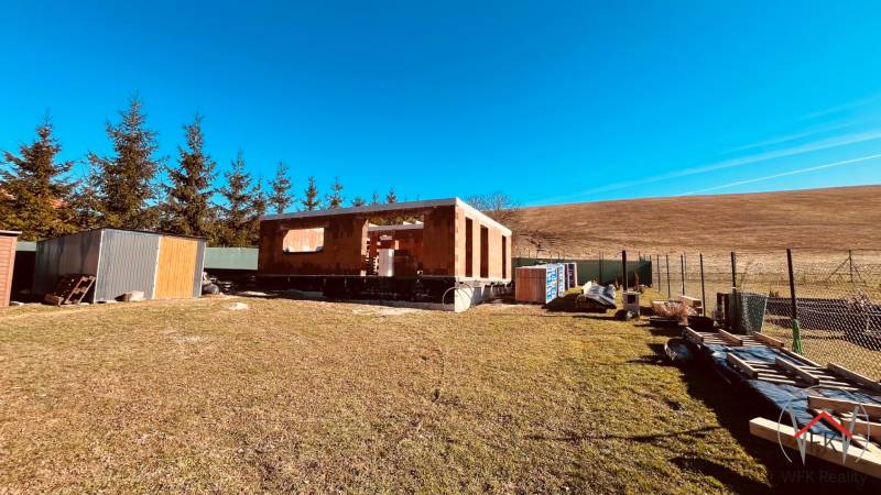 Der Bau von Häusern in Prosačov in der Prosačova-Straße, umgeben von Natur und klarem Himmel.