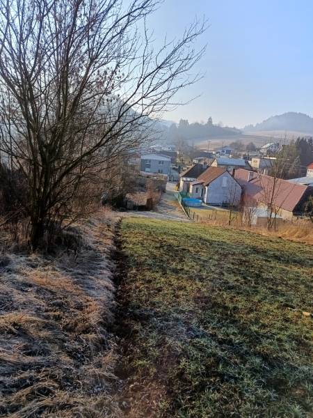 Landschaft in Sklabina mit Grundstücken zum Wohnen, Häusern und Bäumen im Hintergrund.