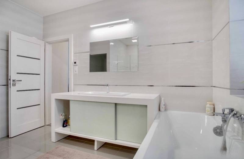 Badezimmer mit Badewanne und Spiegel in einer 3-Zimmer-Wohnung.